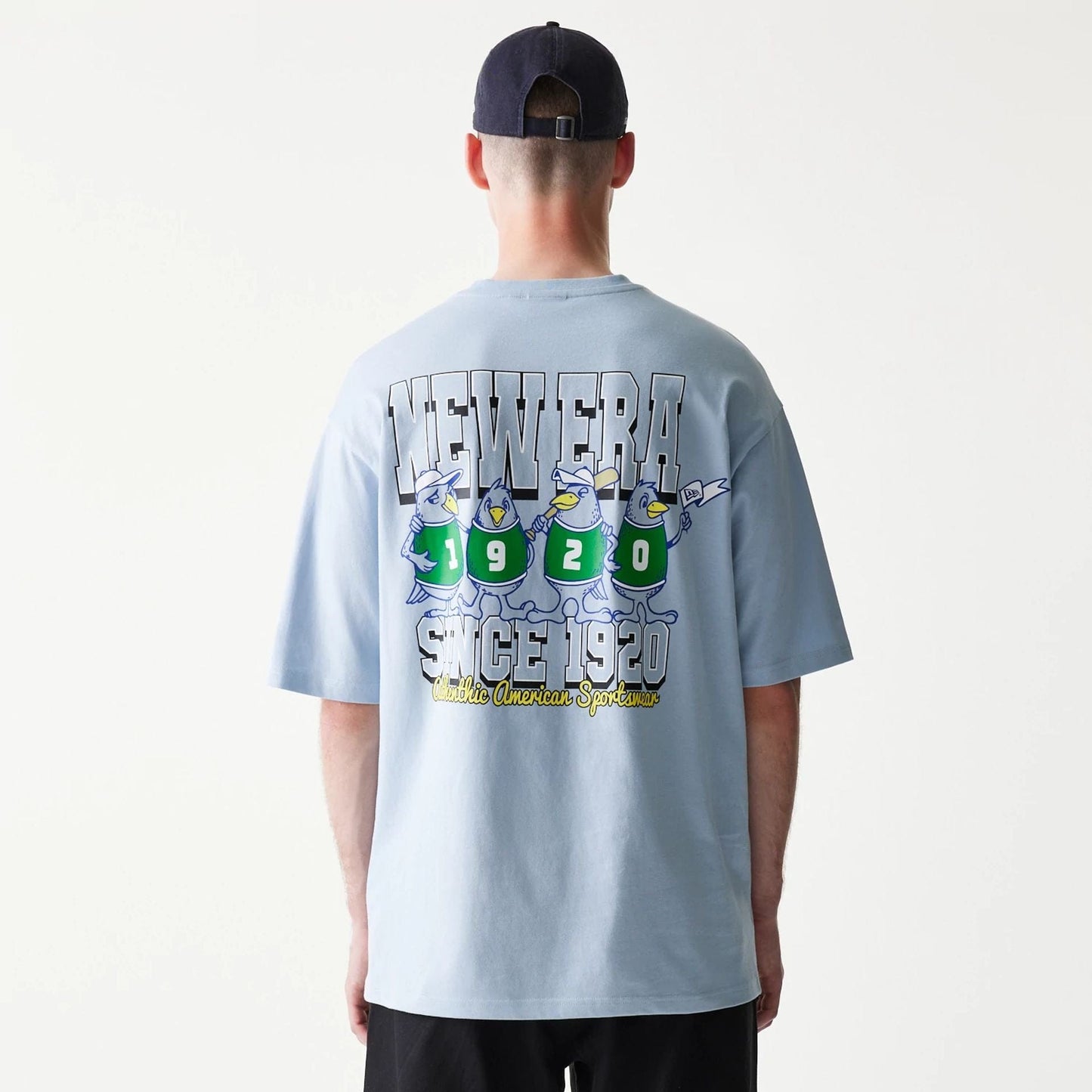 The model is wearing this New Era Baseball Birds Character Graphic Oversized T-Shirt in pastel blue. 2
