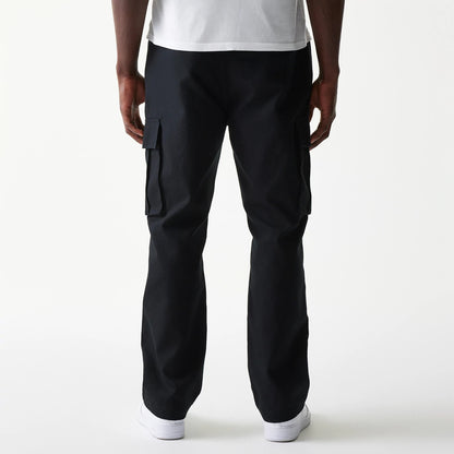 New Era Black Straight Leg Cargo Joggers, rear view on a model showing the relaxed fit and dual large flap pockets on the sides, the hem resting on white trainers.