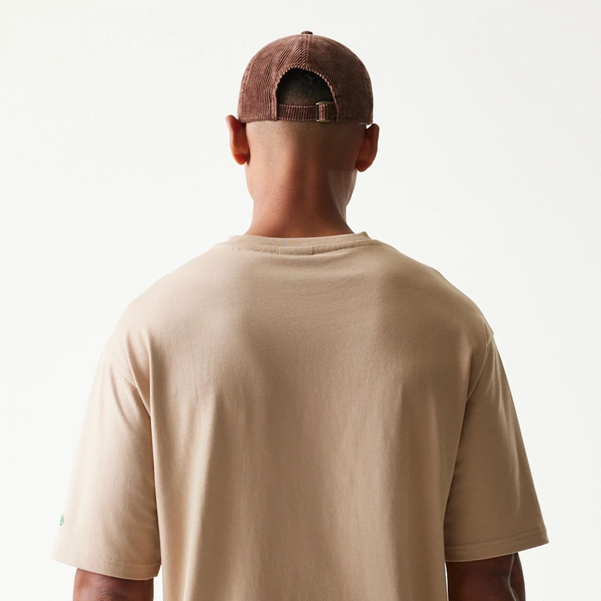 The model is wearing this New Era Orange Fruit Graphic Oversized T-Shirt in light beige. 7