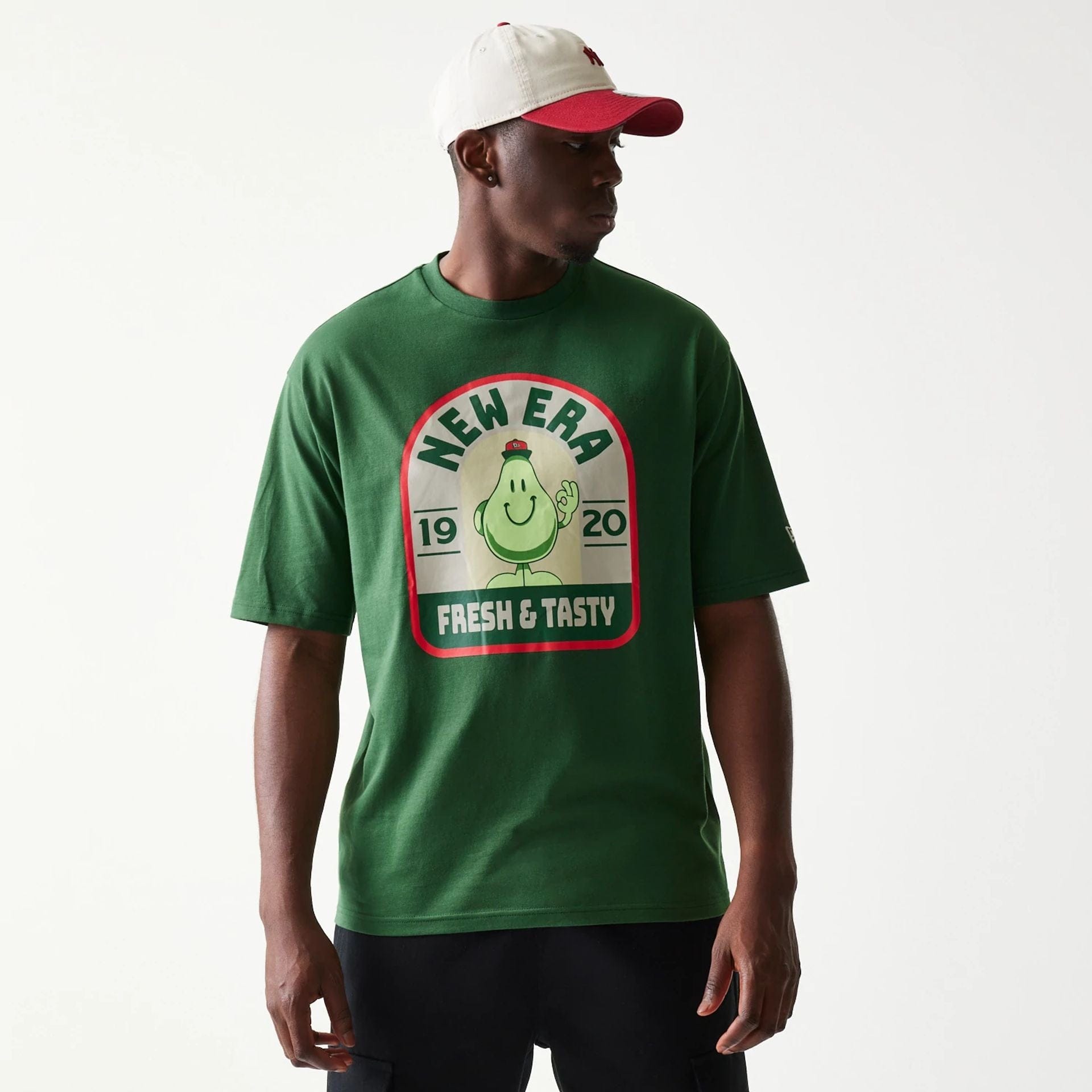 The model is wearing this New Era Pear Fruit Graphic Oversized T-Shirt in dark green. 3