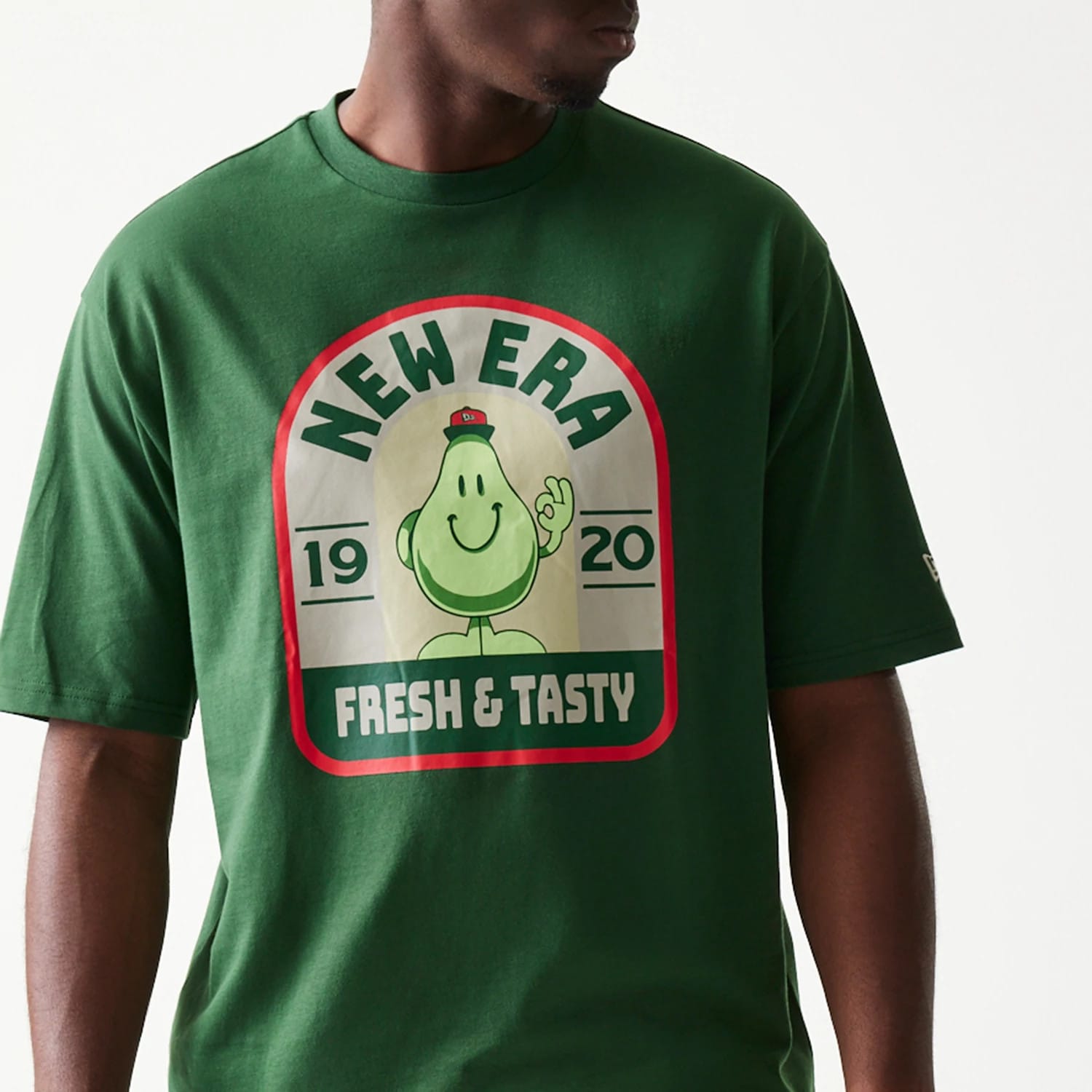 The model is wearing this New Era Pear Fruit Graphic Oversized T-Shirt in dark green. 5