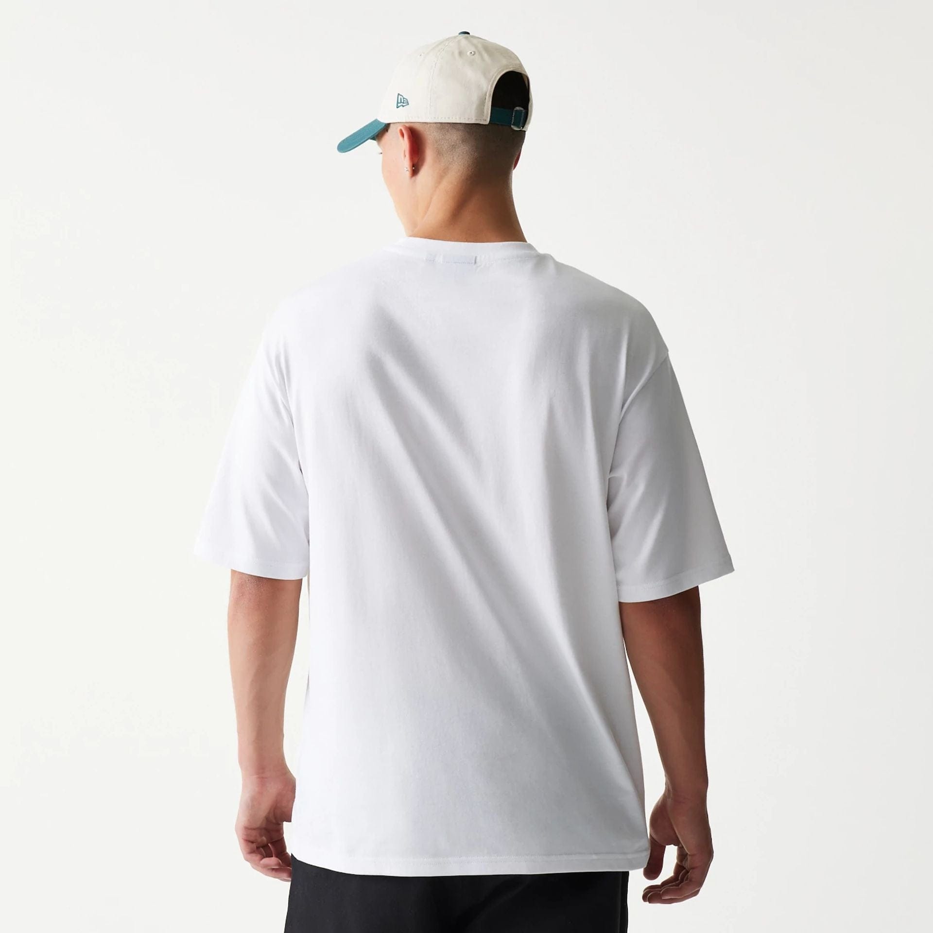 The model is wearing this New Era Baseball Player Graphic Oversized T-Shirt in white. 2
