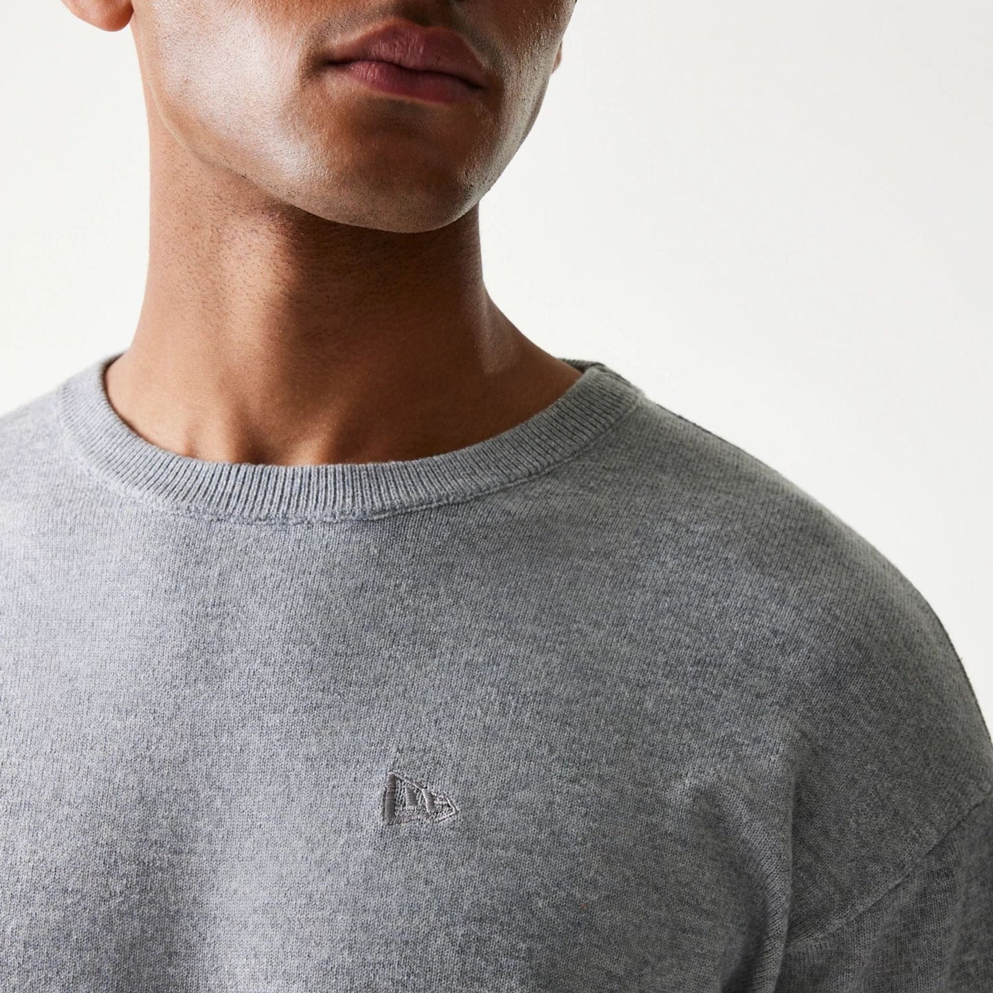The model is wearing this New Era Essential Flag Knitted Sweater in grey. 6