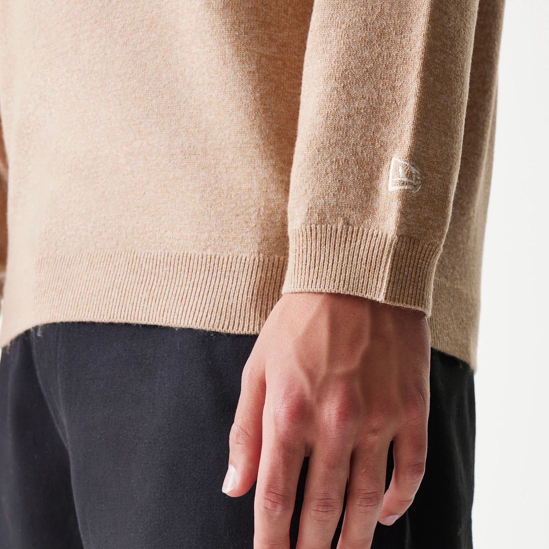 The model is wearing this New Era Essential Flag Knitted Sweater in light beige. 6