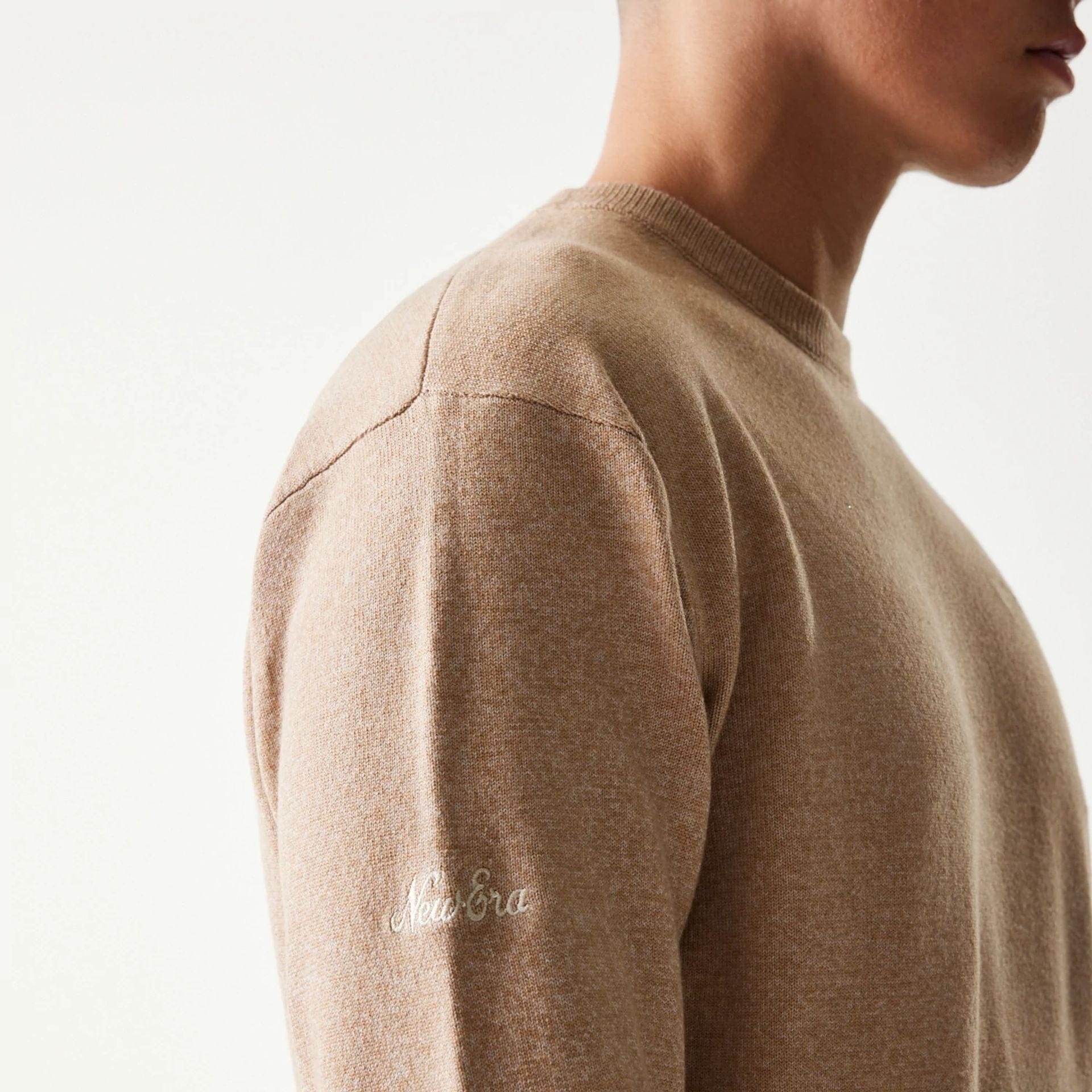 The model is wearing this New Era Essential Flag Knitted Sweater in light beige. 7