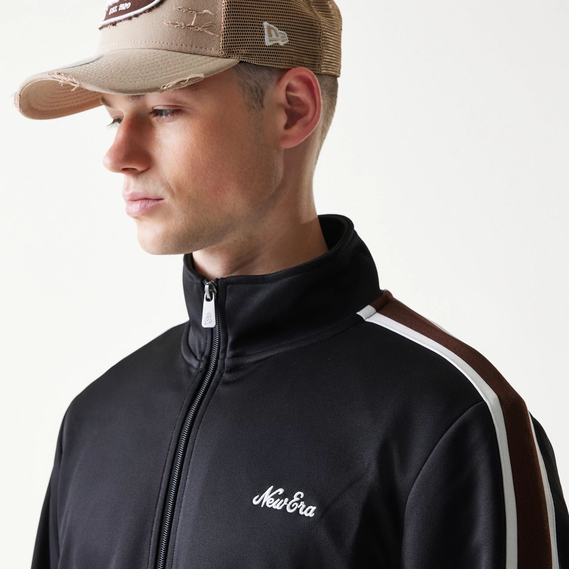 The model is wearing this New Era Script Track Jacket in black. 5