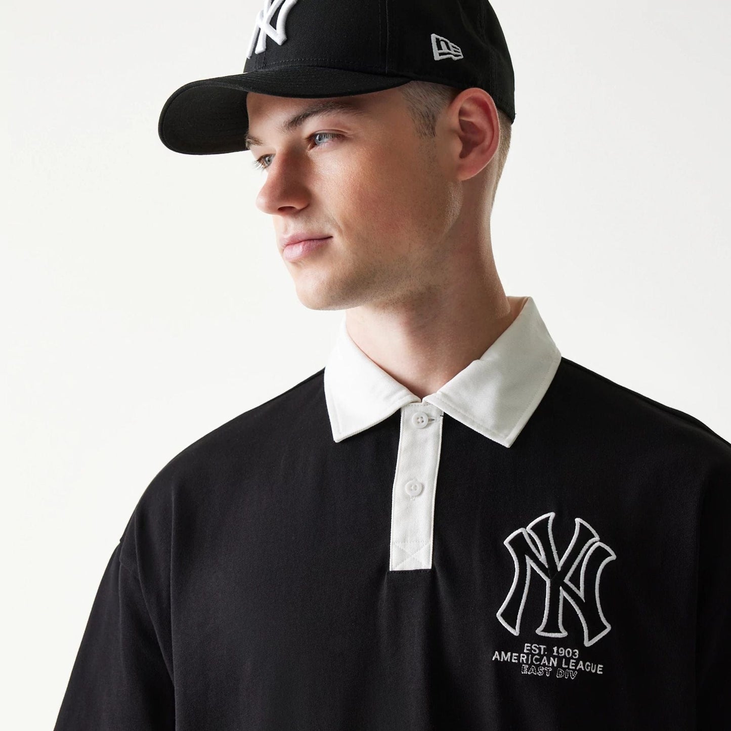 The model is wearing this MLB New York Yankees Oversized Polo T-Shirt in black. 4