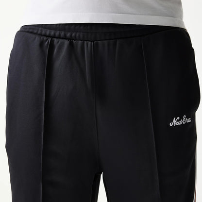 New Era Script Black Straight Leg Joggers, close-up view showing the white embroidered New Era script logo on the left side near the waist, with pleated on the black fabric and an elasticated waistband.