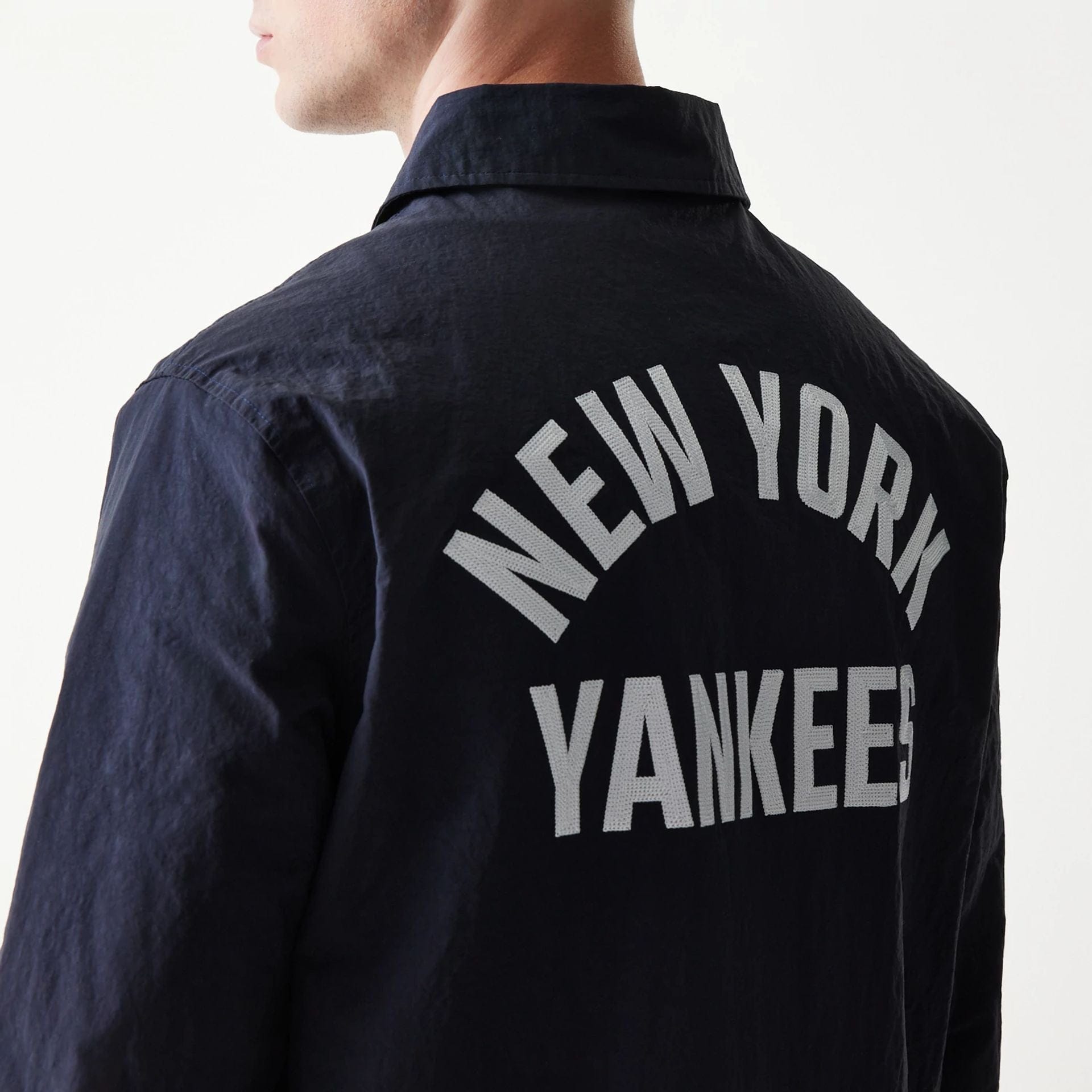 The model is wearing this MLB Coaches New York Yankees Jacket in navy. 4
