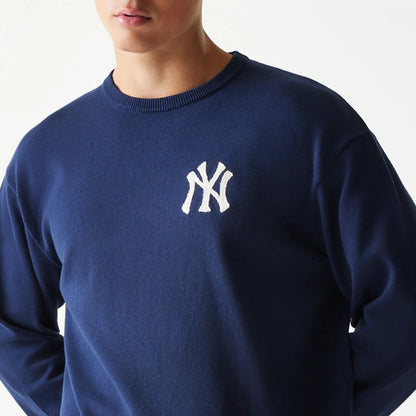 New Era New York Yankees MLB Essential Navy Knitted Sweater, front view on a model showing the white embroidered NY logo on the left chest against the rich navy fabric, with a ribbed crew neck design.