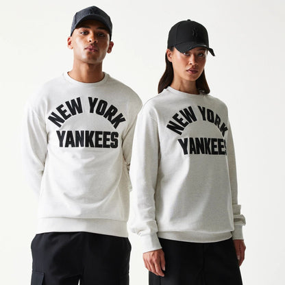 The model is wearing this MLB Graphic New York Yankees Oversized Crew Neck Sweater in pastel grey. 1