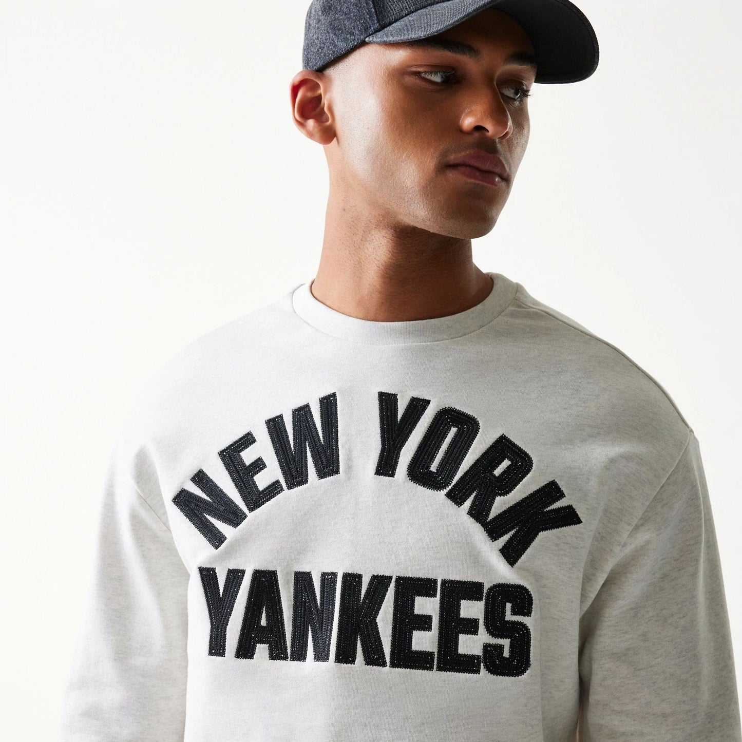 The model is wearing this MLB Graphic New York Yankees Oversized Crew Neck Sweater in pastel grey. 6