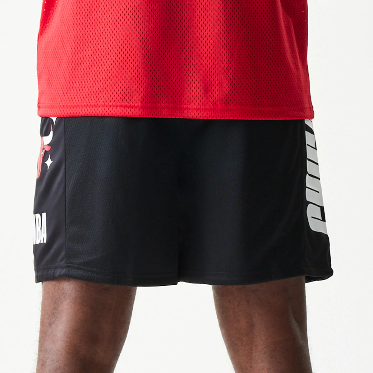 New Era Chicago Bulls NBA Mesh Black Shorts, front view showing the black mesh fabric with a white printed Chicago Bulls logo on the side and white lettering running vertically along the opposite side.