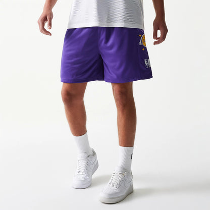 New Era LA Lakers NBA Mesh Purple Shorts, front view showing the embroidered Lakers logo on the left leg in yellow and white, set against the purple mesh fabric, worn with white socks and trainers.