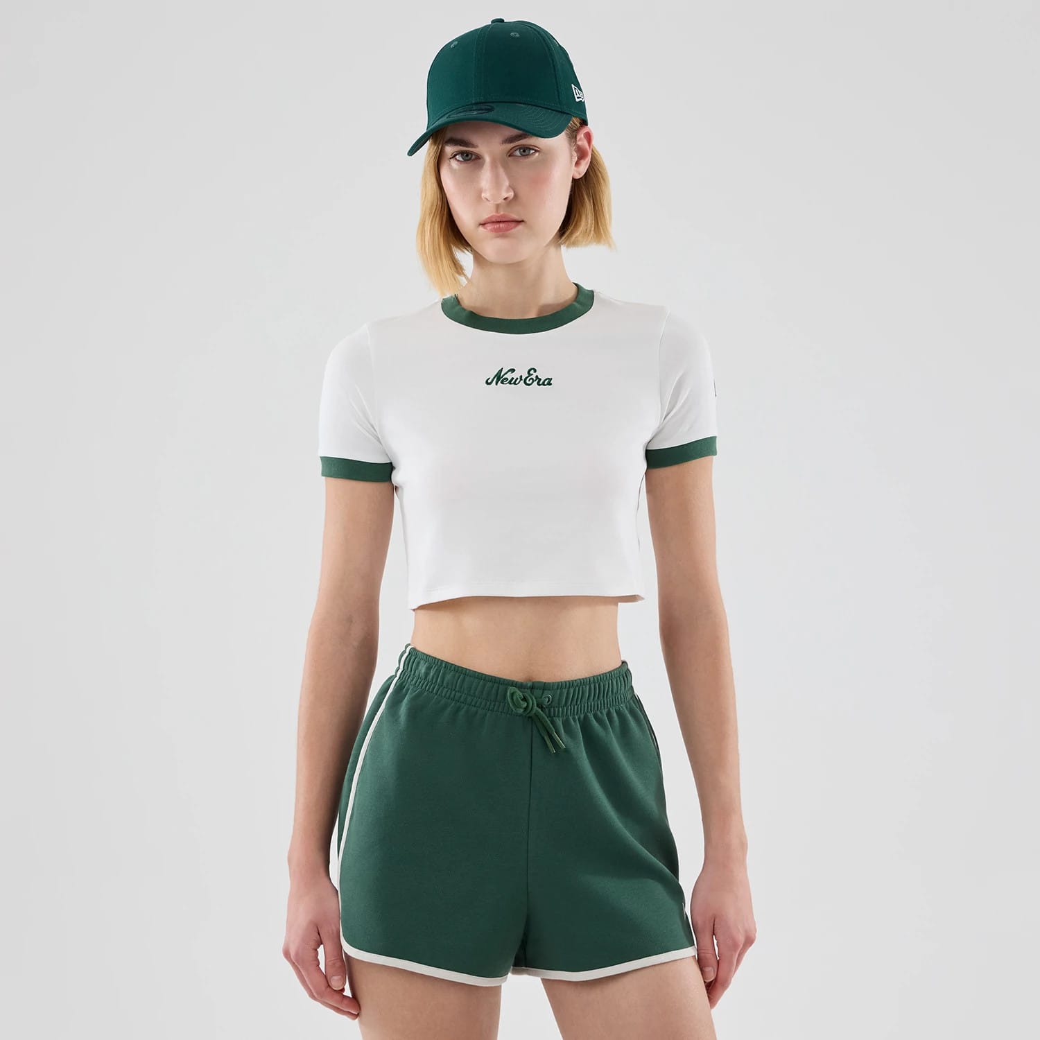 The model is wearing this Womens New Era Cropped Slim T-shirt in white. 1