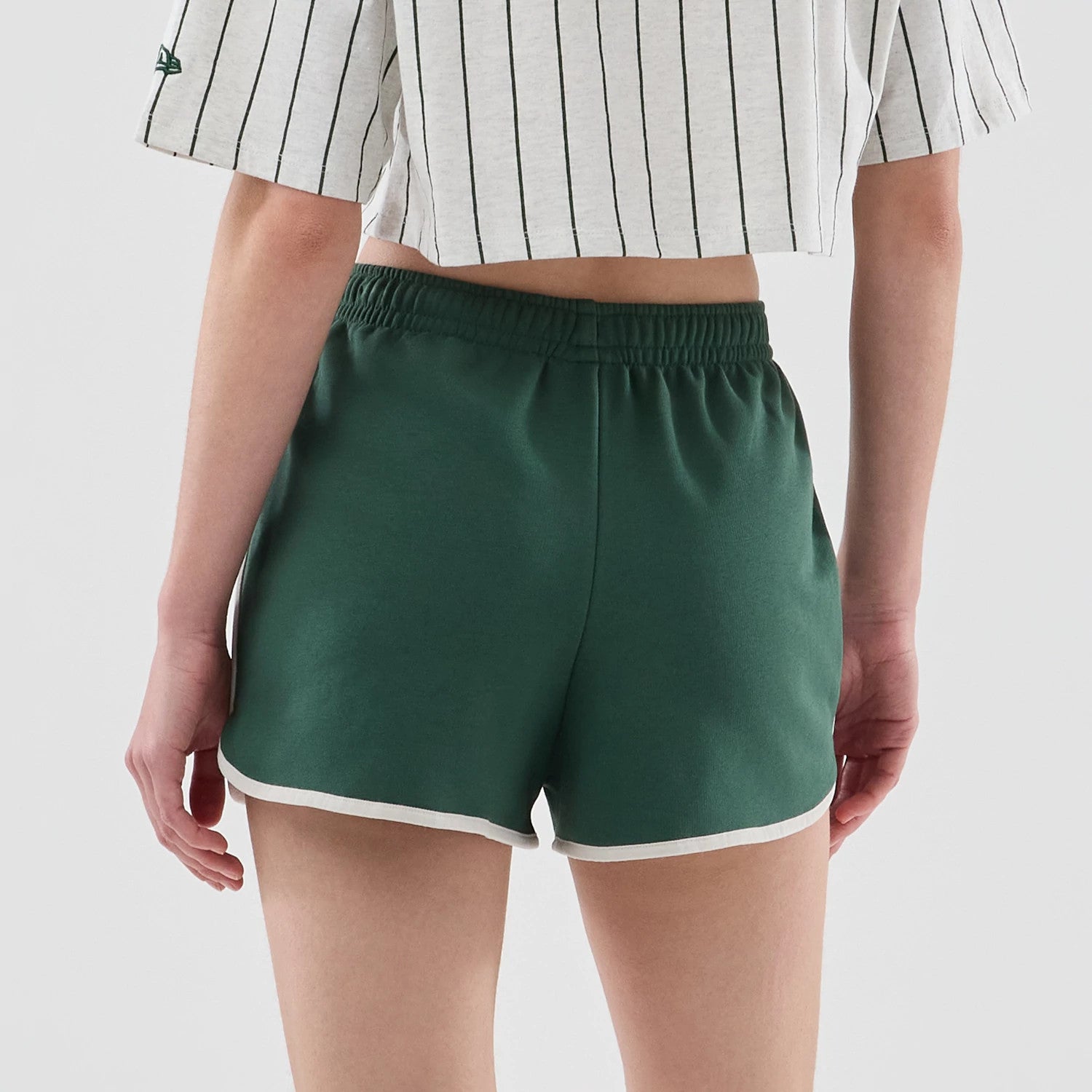 The model is wearing this Womens New Era Track Shorts in dark green. 7