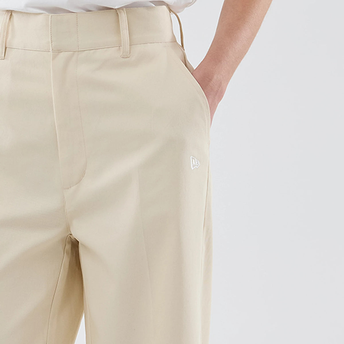New Era New York Yankees Womens MLB Cream Chino Trousers, front view showing the white embroidered New Era flag logo on the upper left thigh, with a flat front design and hidden hook-and-eye closure.