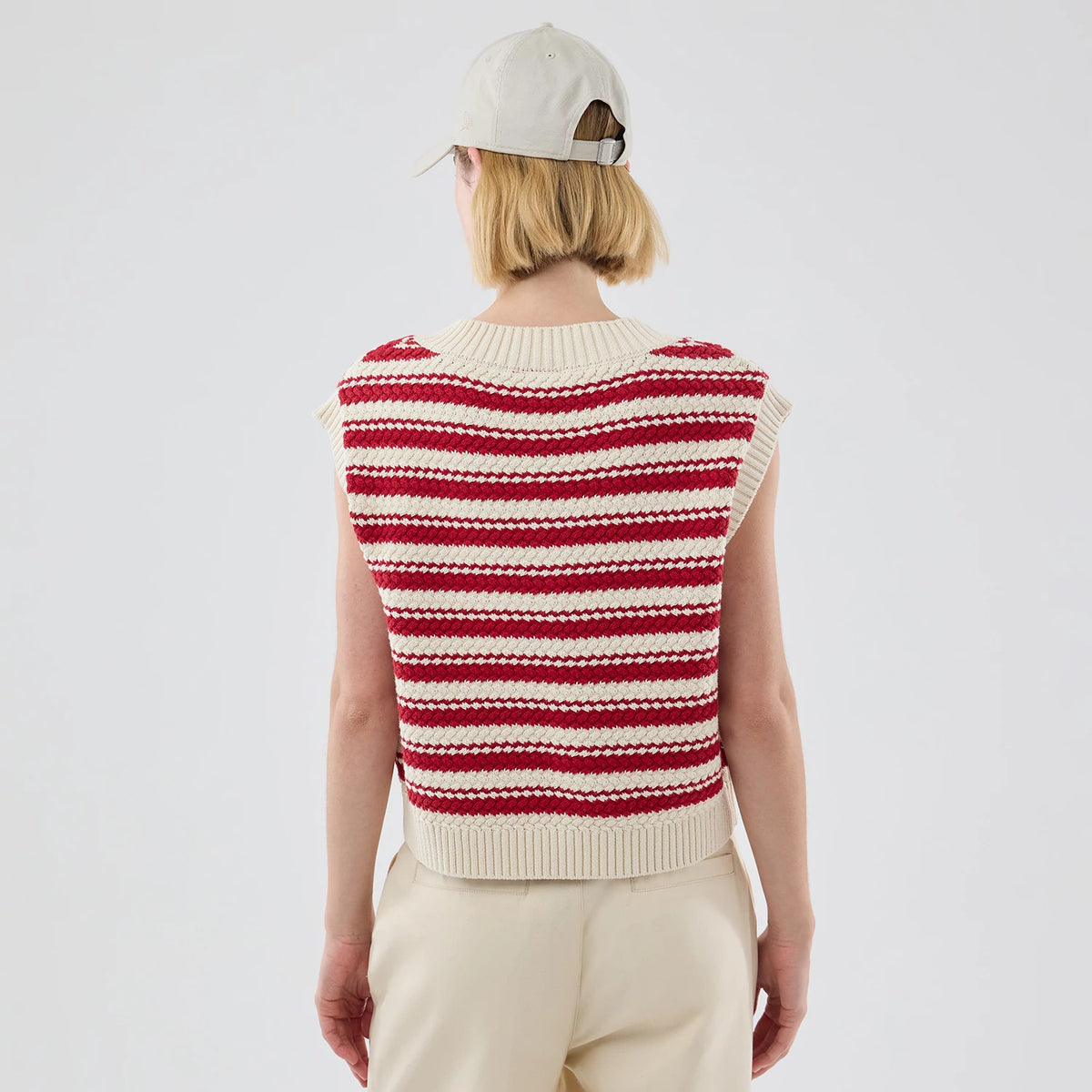 New Era New York Yankees Womens MLB Knit Stripe Dark Red Sleeveless V-neck Sweater, back view on a model with a cream cap, showing horizontal dark red and cream stripes with ribbed edging at the collar and hem.