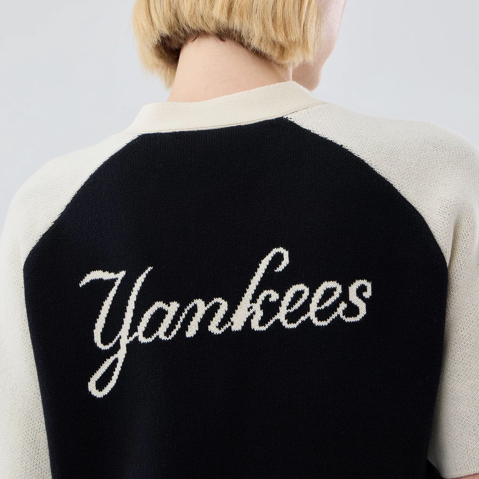 The model is wearing this Womens MLB Knit Stripe New York Yankees Short Sleeve Cardigan in black. 7
