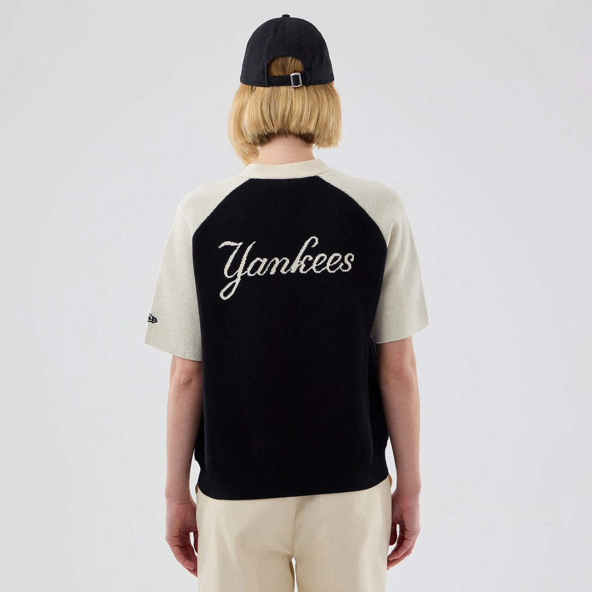 New Era New York Yankees Womens MLB Knit Stripe Black Short Sleeve Cardigan, back view on a model wearing a black cap, featuring Yankees script lettering across the black back panel.