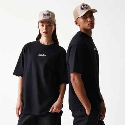 The model is wearing this New Era Heritage Script T-Shirt in black. 1