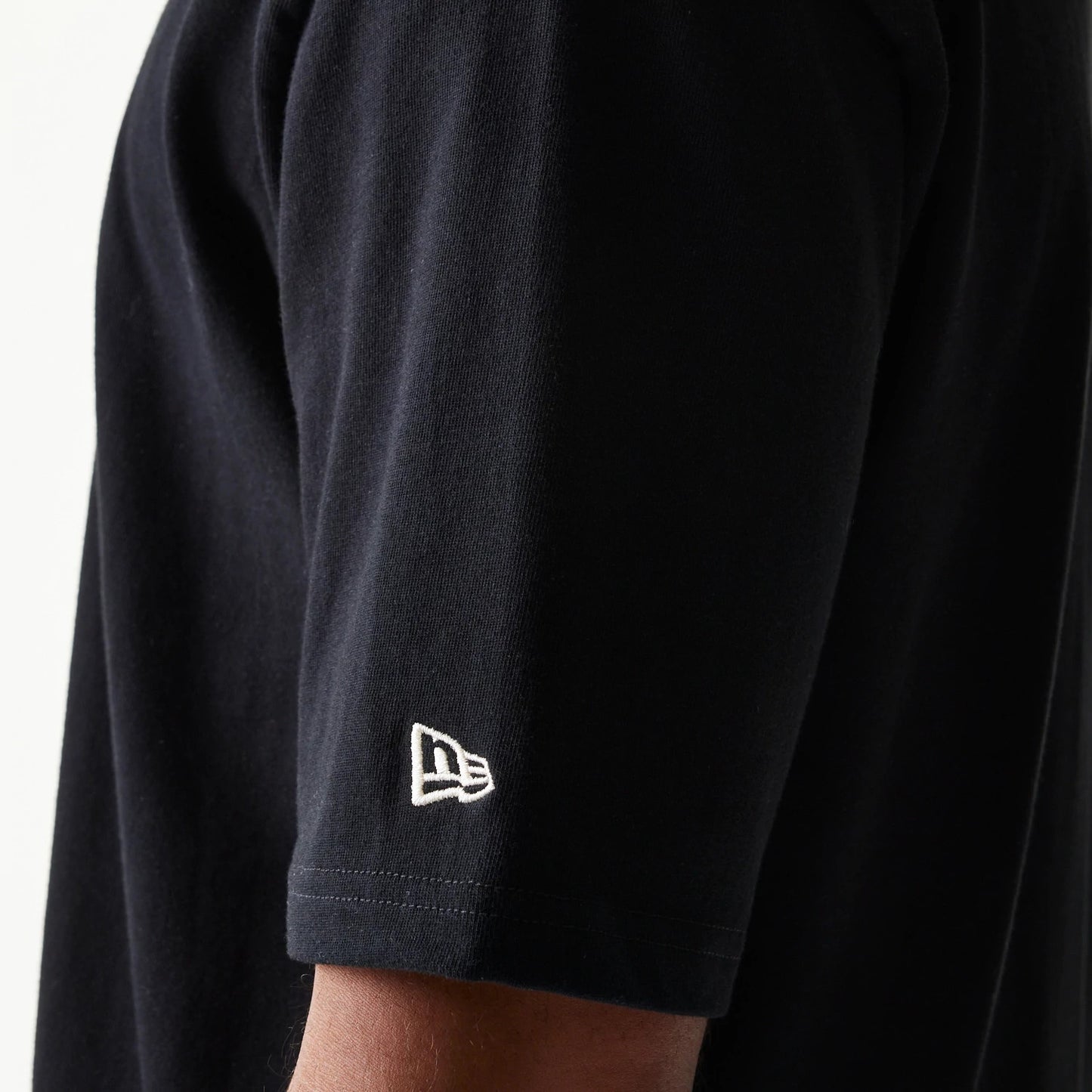 The model is wearing this New Era Heritage Script T-Shirt in black. 6