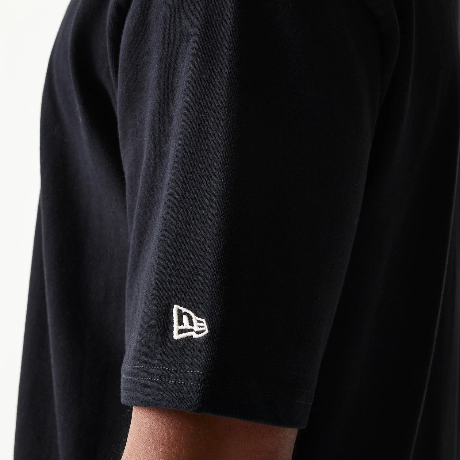 The model is wearing this New Era Heritage Script T-Shirt in black. 6