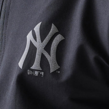 New Era New York Yankees MLB Black Track Jacket, close-up front view showcasing a grey printed Yankees logo on the left side near the zip seam, with the MLB and New Era logos positioned beneath it on the black fabric.