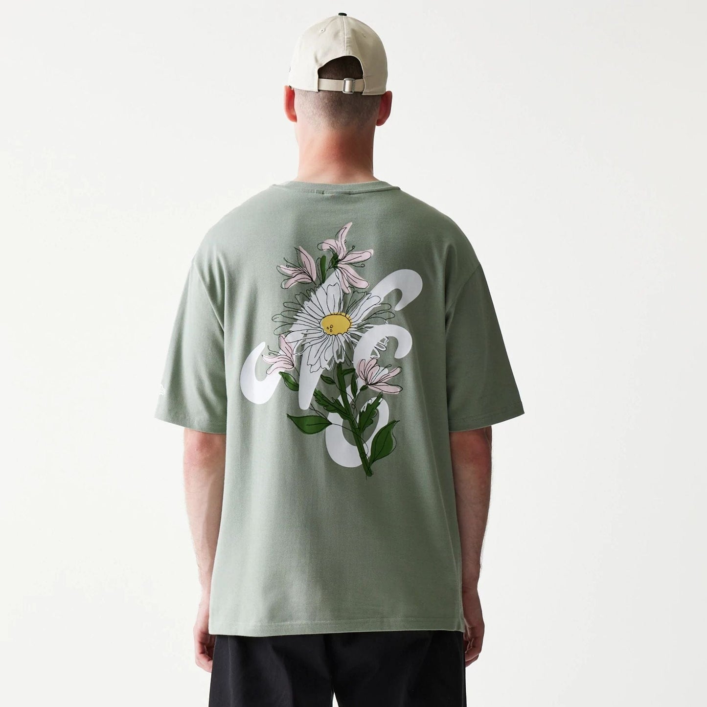 The model is wearing this New Era Floral Graphic Oversized T-Shirt in pastel green. 2