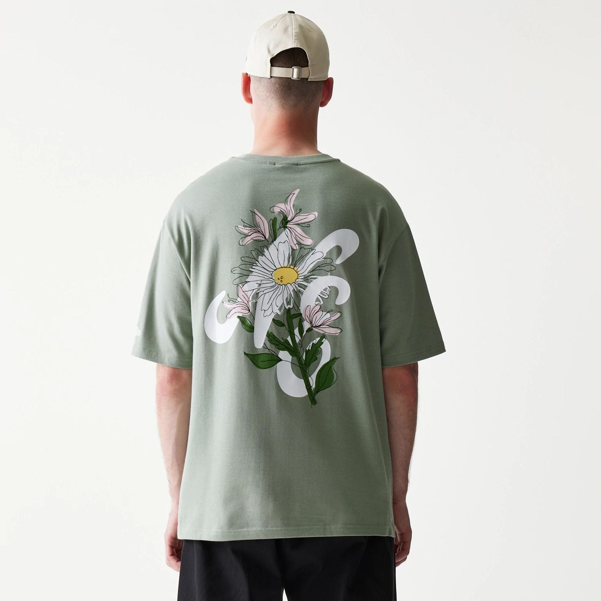 The model is wearing this New Era Floral Graphic Oversized T-Shirt in pastel green. 2