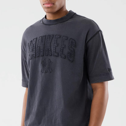 New Era New York Yankees MLB Washed Black T-Shirt, front view on-model showing the raised Yankees lettering across the chest, with an embroidered logo below and a small New Era logo on the left sleeve.