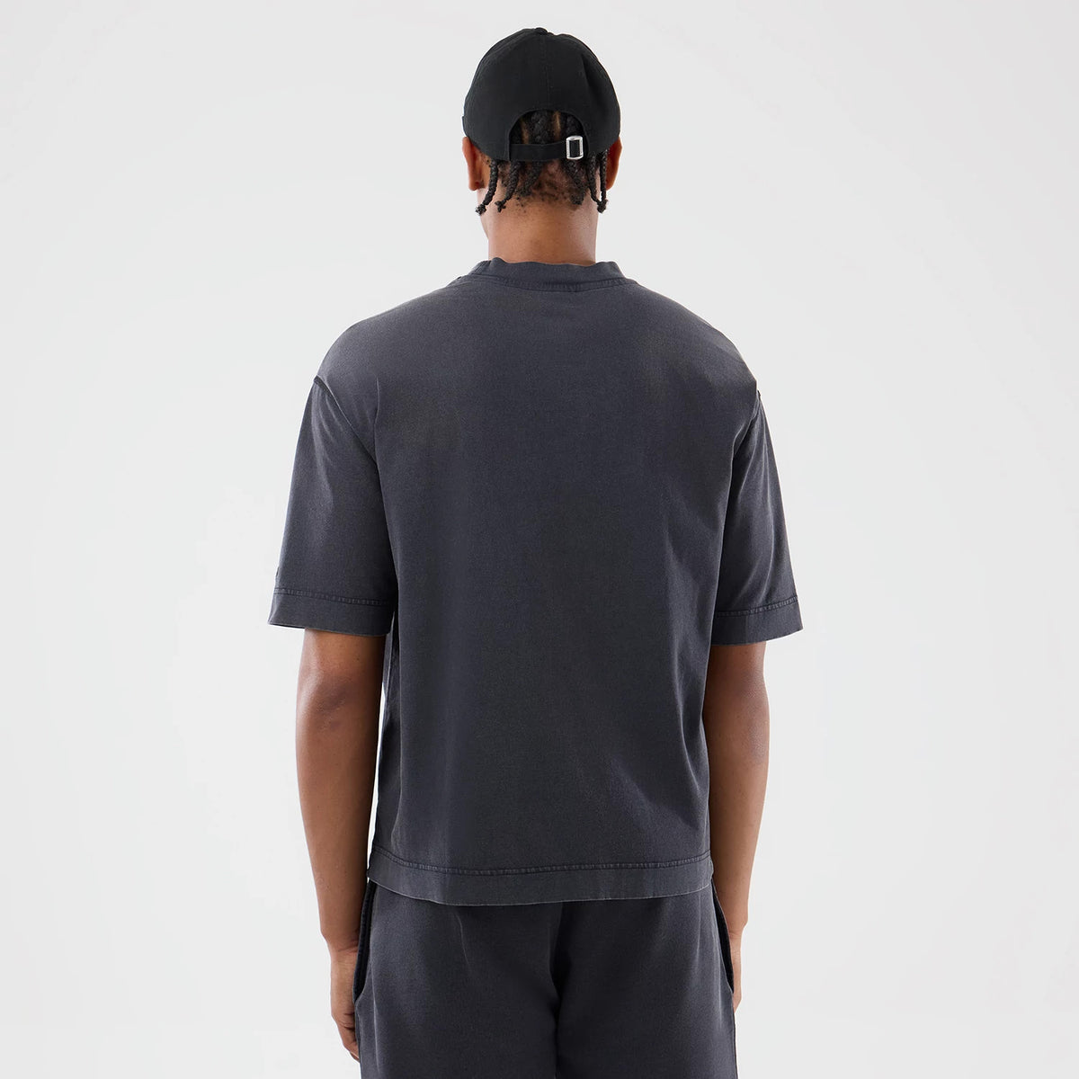 New Era New York Yankees MLB Washed Black T-Shirt, back view on-model paired with matching shorts, showing the plain washed black fabric with short sleeves and a relaxed fit, no design or logo on the back panel.