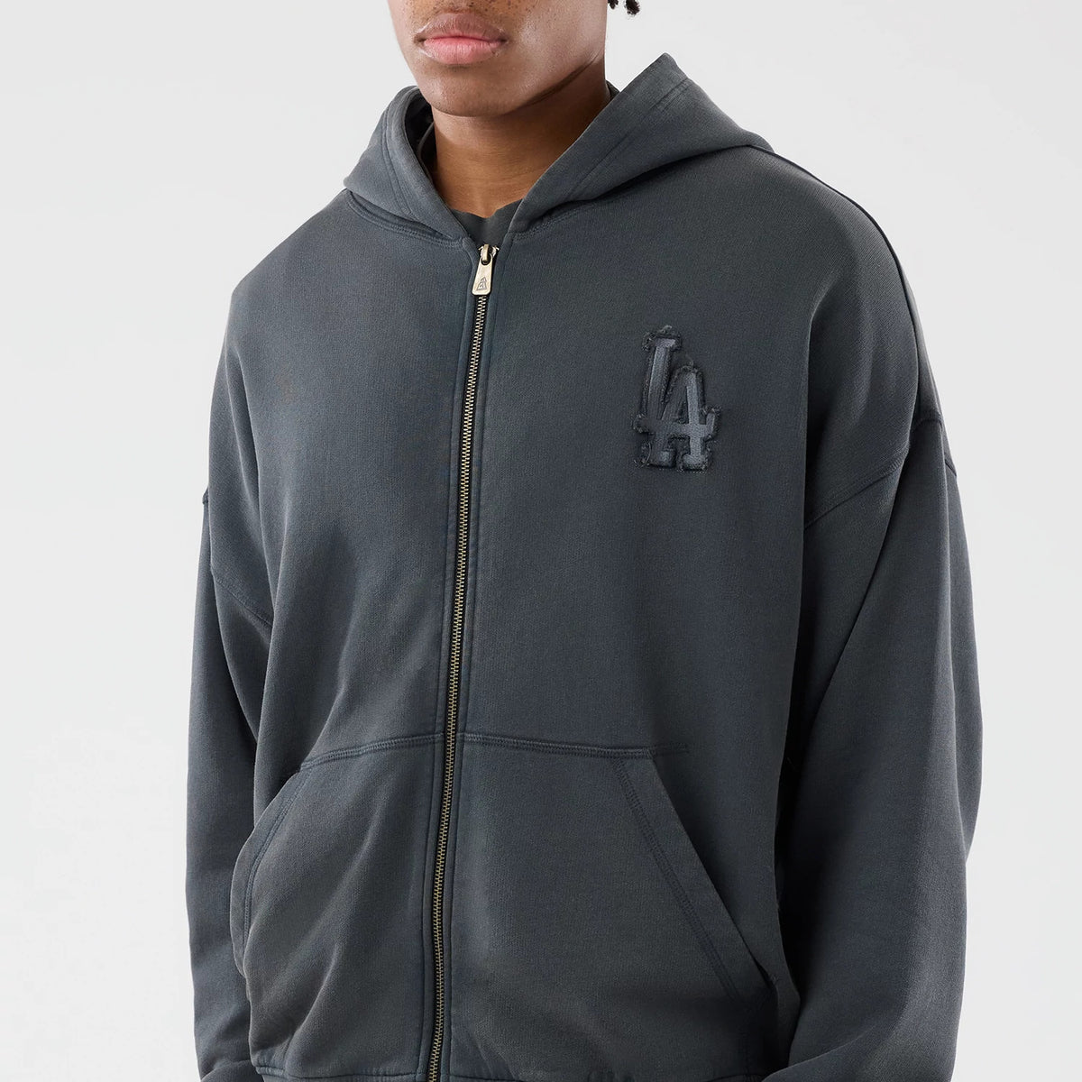 New Era LA Dodgers MLB Washed Dark Grey Full Zip Hoodie, front view on-model showcasing a full-length zip, a drawstring hood, and a raised LA logo on the left chest, complemented by the dark grey tone of the fabric.