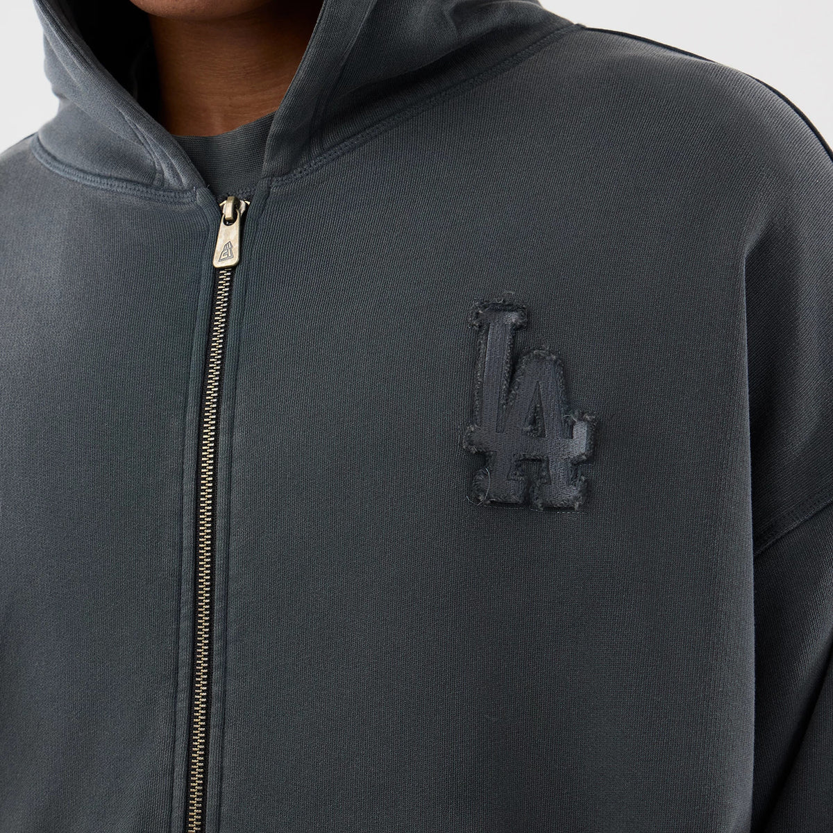 New Era LA Dodgers MLB Washed Dark Grey Full Zip Hoodie, front view showing a dark grey hoodie worn by a model with a full-length zip, featuring an embroidered LA logo on the left chest.