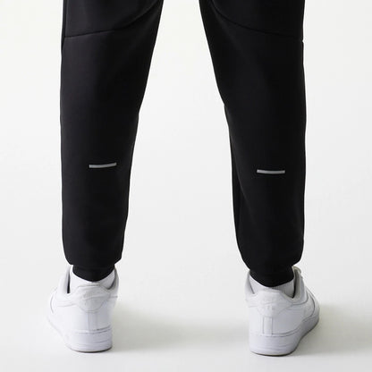 New Era New York Yankees MLB Black Joggers, rear view on a model showing reflective stripes on the lower legs, with elasticated cuffs and paired with white trainers, emphasising a casual athletic style.