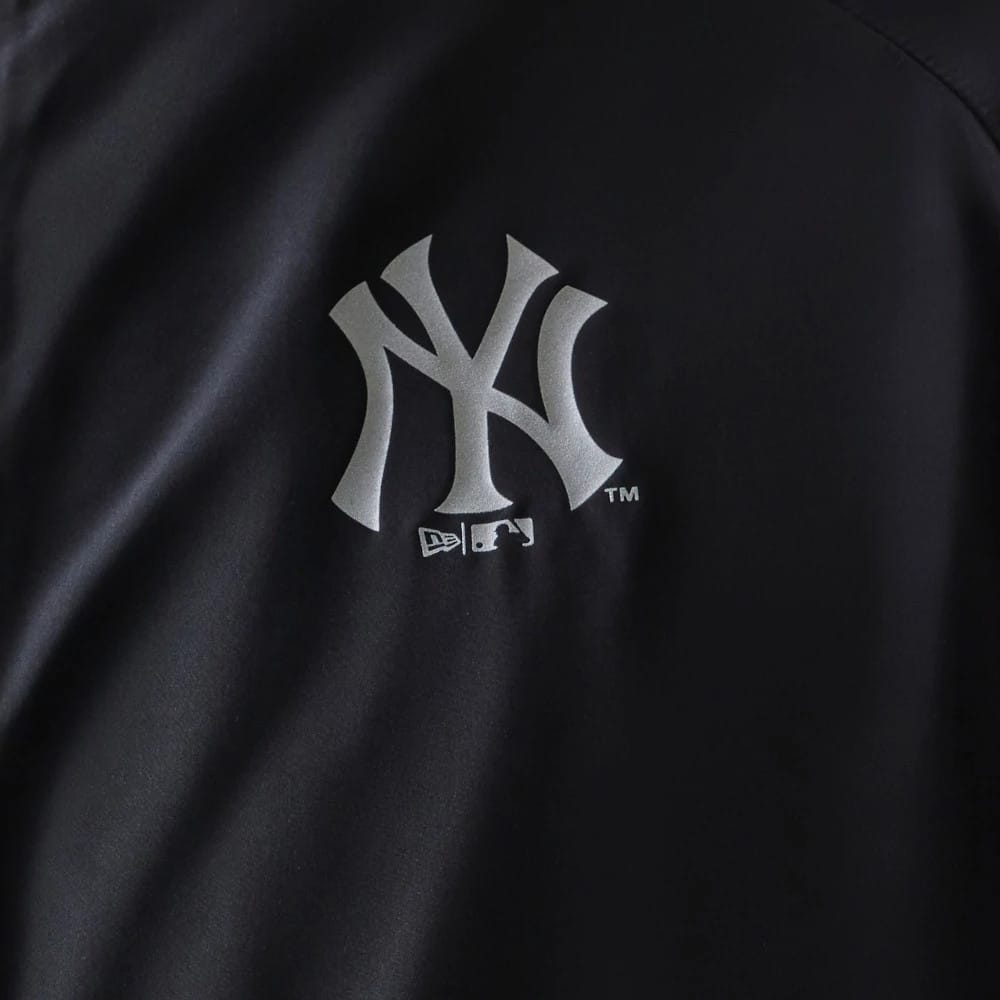The model is wearing this MLB Reflective Strip New York Yankees Jacket in black. 5