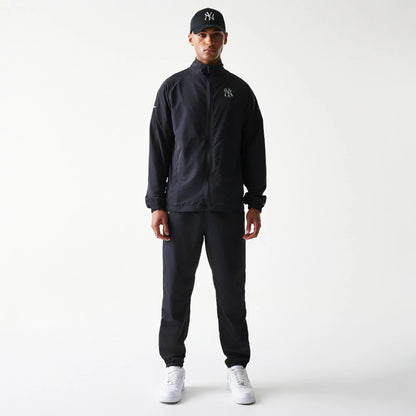 The model is wearing this MLB Reflective Logo New York Yankees Track Pants in black. 8