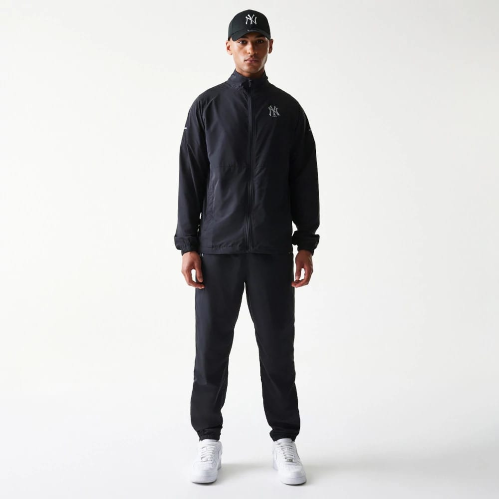 The model is wearing this MLB Reflective Logo New York Yankees Track Pants in black. 8