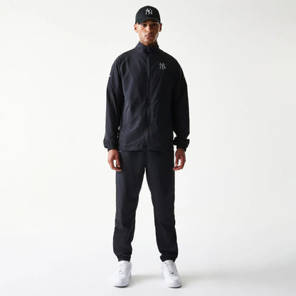The model is wearing this MLB Reflective Logo New York Yankees Track Pants in black. 8