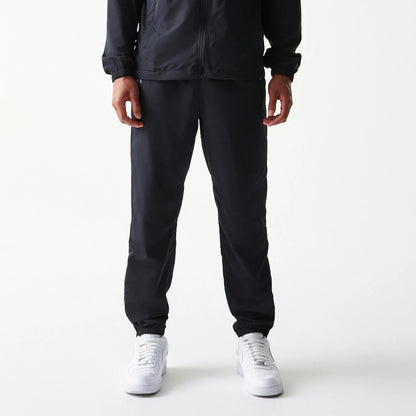 The model is wearing this MLB Reflective Logo New York Yankees Track Pants in black. 1