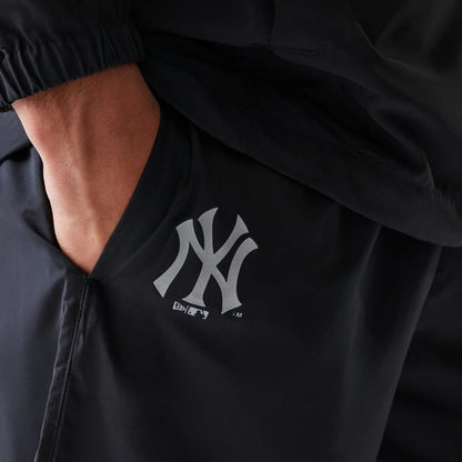 The model is wearing this MLB Reflective Logo New York Yankees Track Pants in black. 3