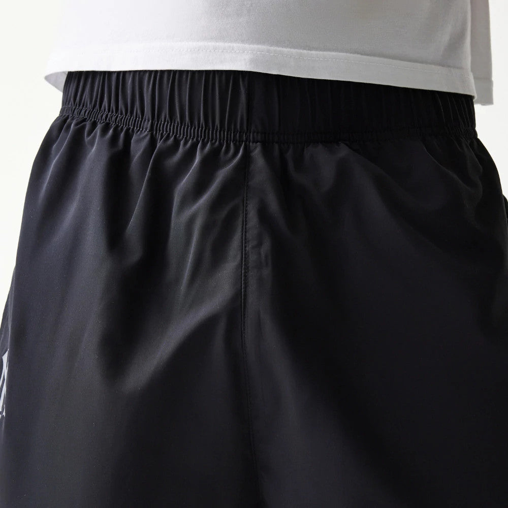 The model is wearing this MLB Reflective Logo New York Yankees Track Pants in black. 6