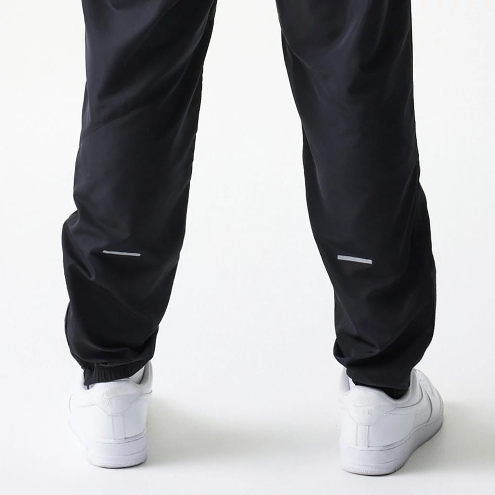 The model is wearing this MLB Reflective Logo New York Yankees Track Pants in black. 5