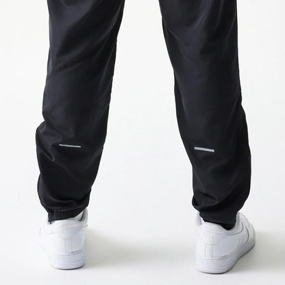 The model is wearing this MLB Reflective Logo New York Yankees Track Pants in black. 5