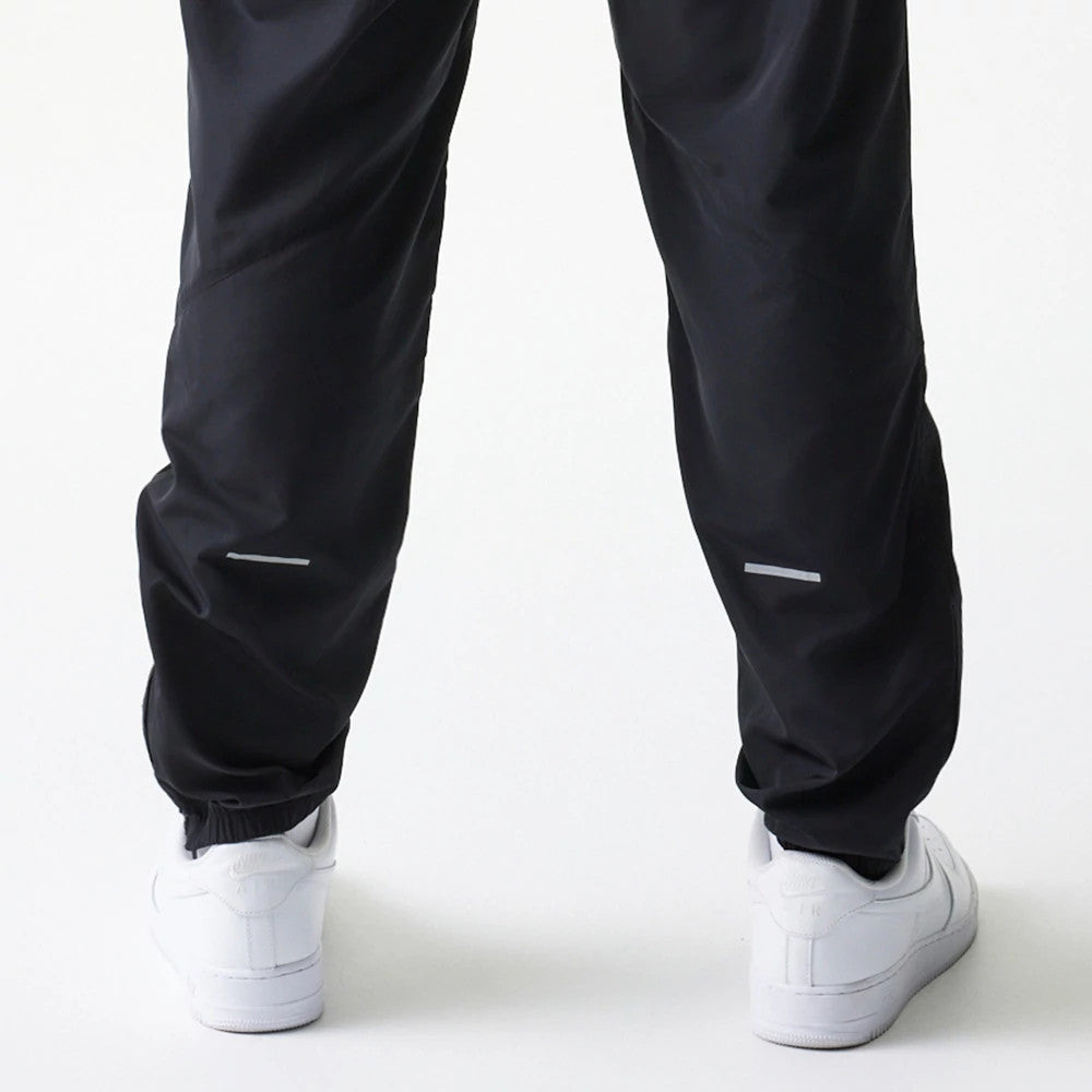 The model is wearing this MLB Reflective Logo New York Yankees Track Pants in black. 5