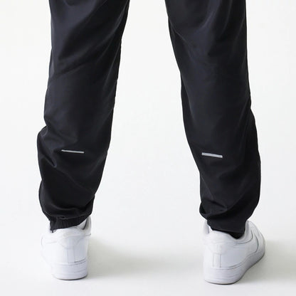 The model is wearing this MLB Reflective Logo New York Yankees Track Pants in black. 5