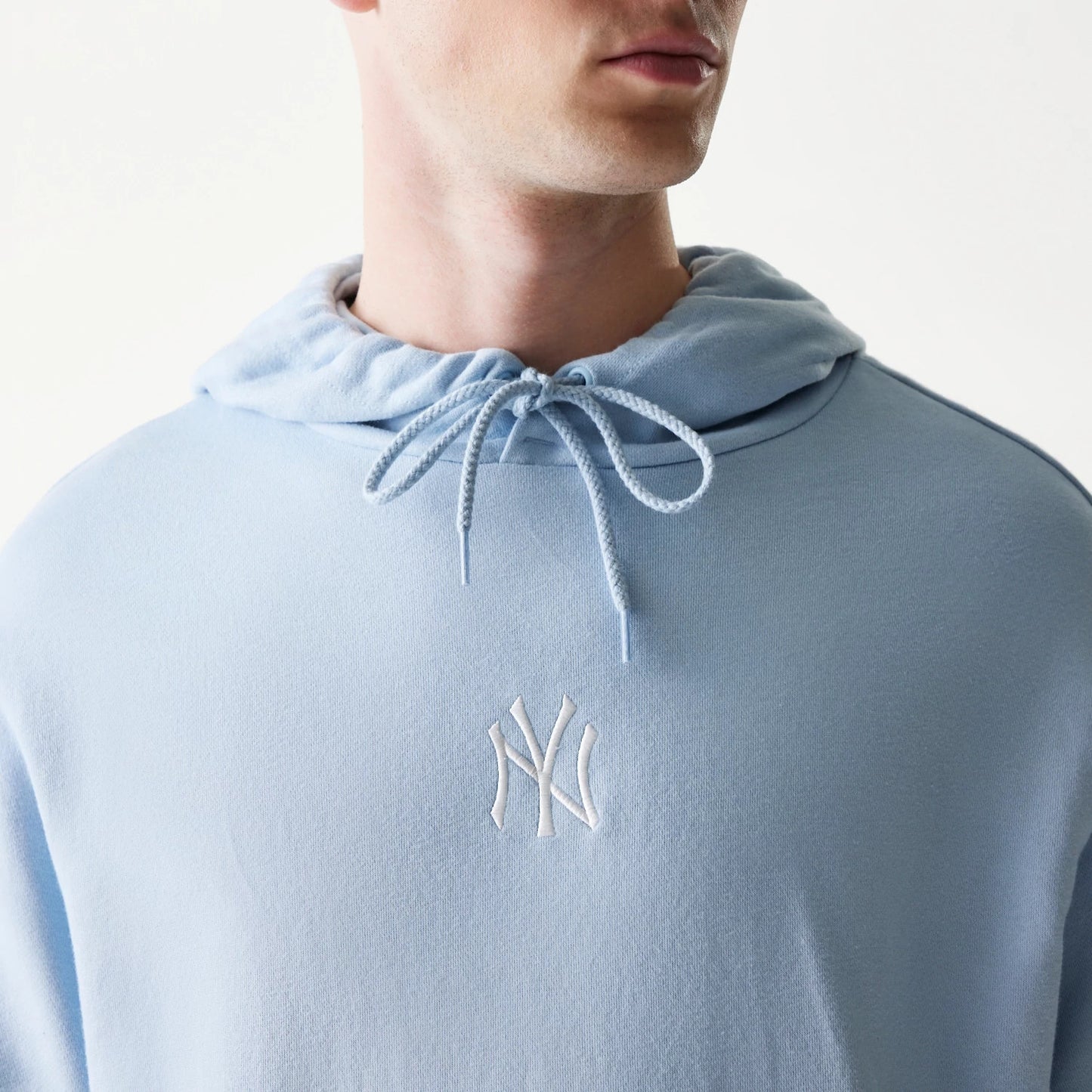 The model is wearing this MLB League Essential Midi New York Yankees Oversized Pullover Hoodie in pastel blue. 4