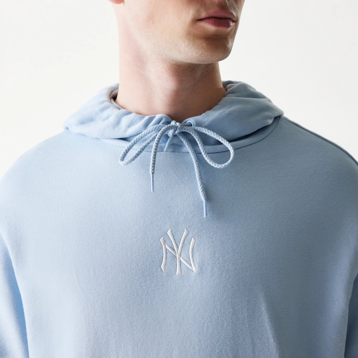 The model is wearing this MLB League Essential Midi New York Yankees Oversized Pullover Hoodie in pastel blue. 4