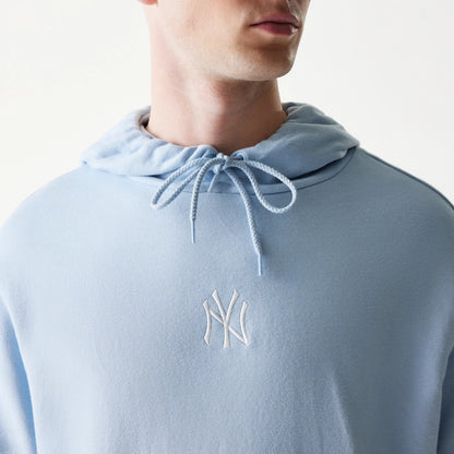 The model is wearing this MLB League Essential Midi New York Yankees Oversized Pullover Hoodie in pastel blue. 4