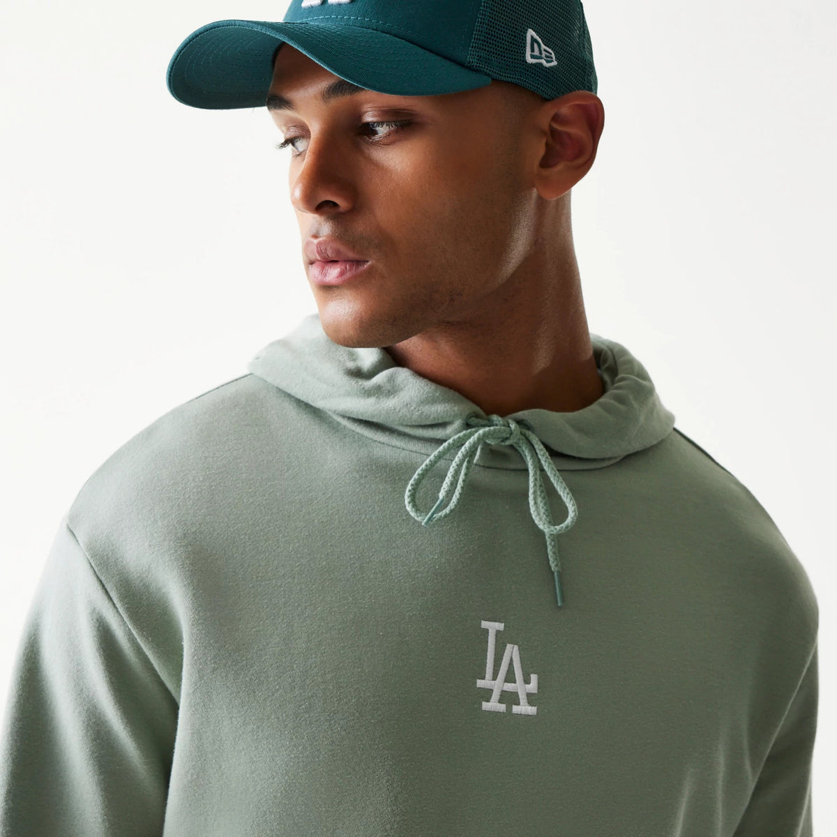 The model is wearing this MLB League Essential Midi LA Dodgers Oversized Pullover Hoodie in green. 4